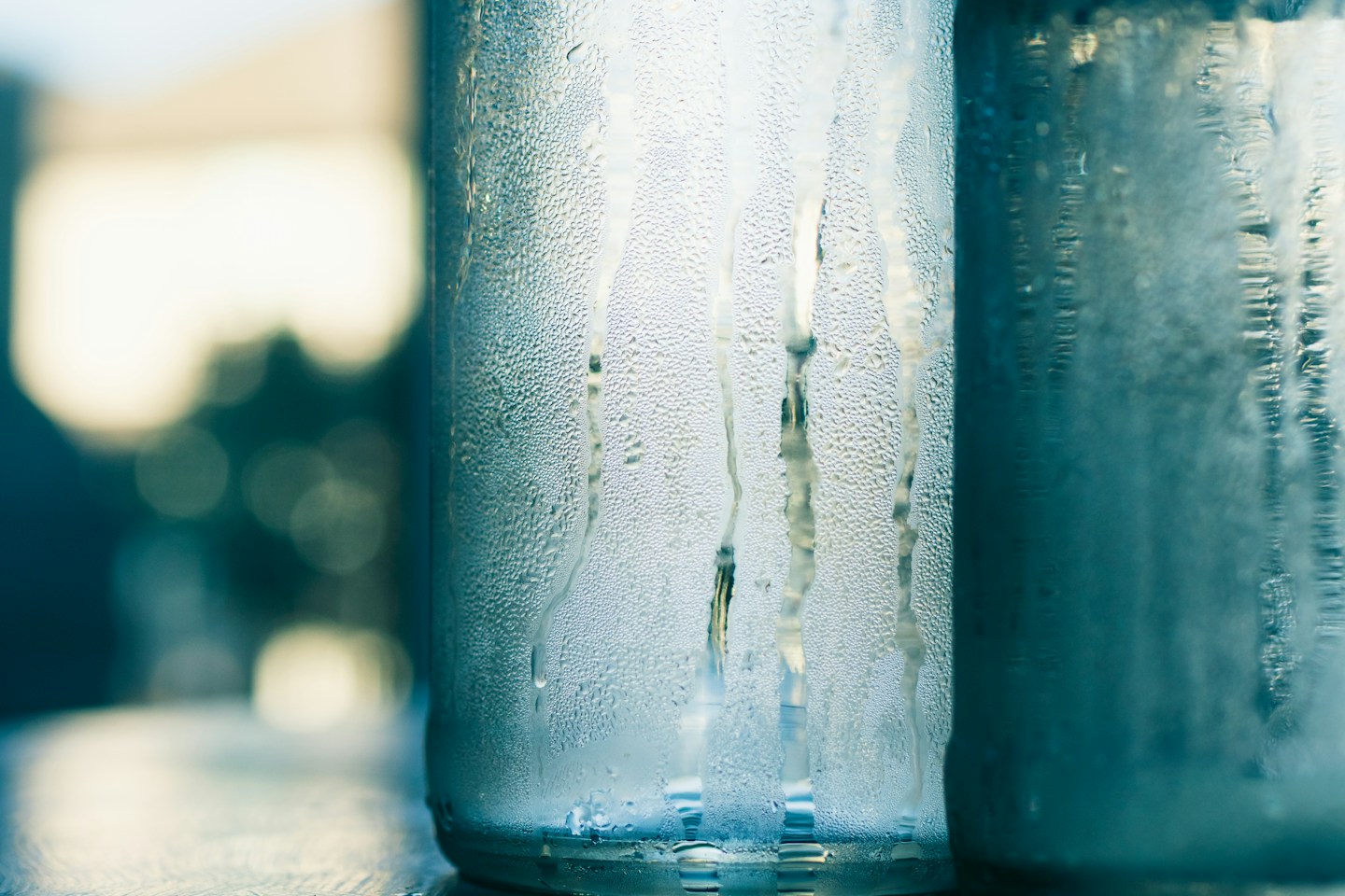 Unbranded glass water bottles with condensation